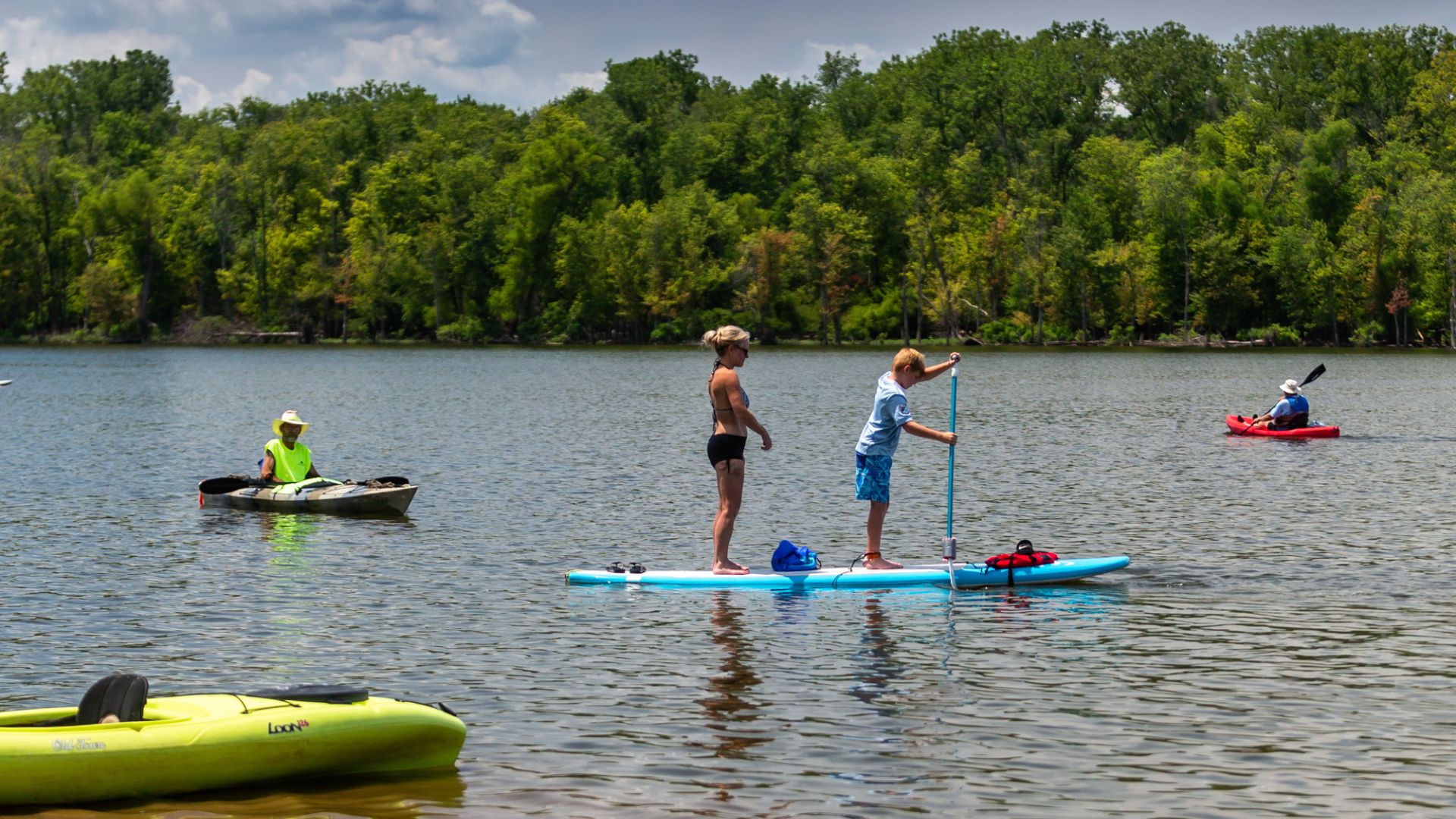 A mother and son stand-up paddleboard on Creve Coeur Lake in one of the best St Louis parks.