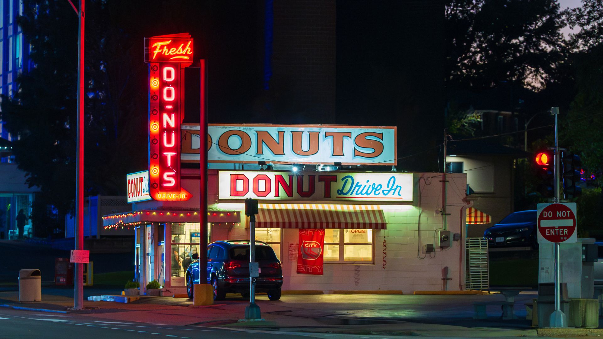 Lit by a neon sign, Donut Drive-In serves the best donuts along Route 66.