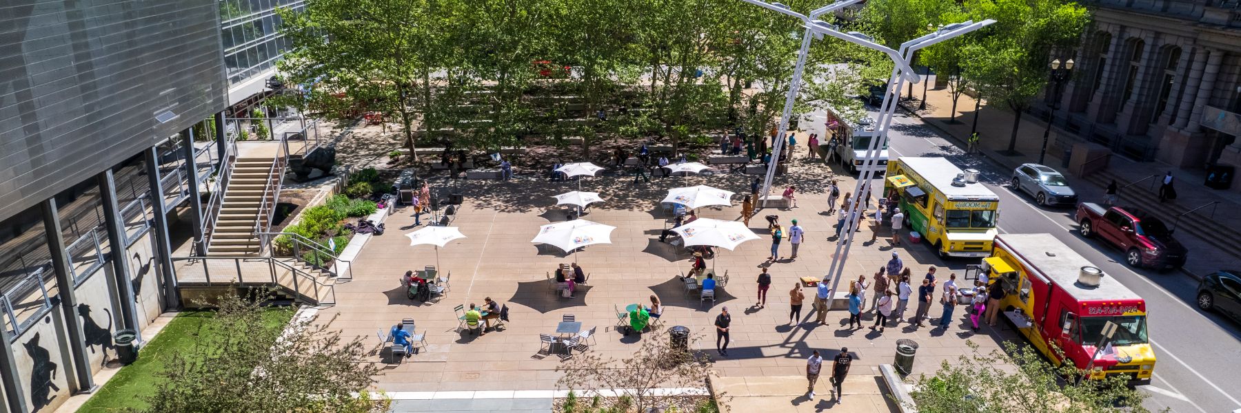 People enjoy lunch in a sunny plaza in downtown St. Louis.