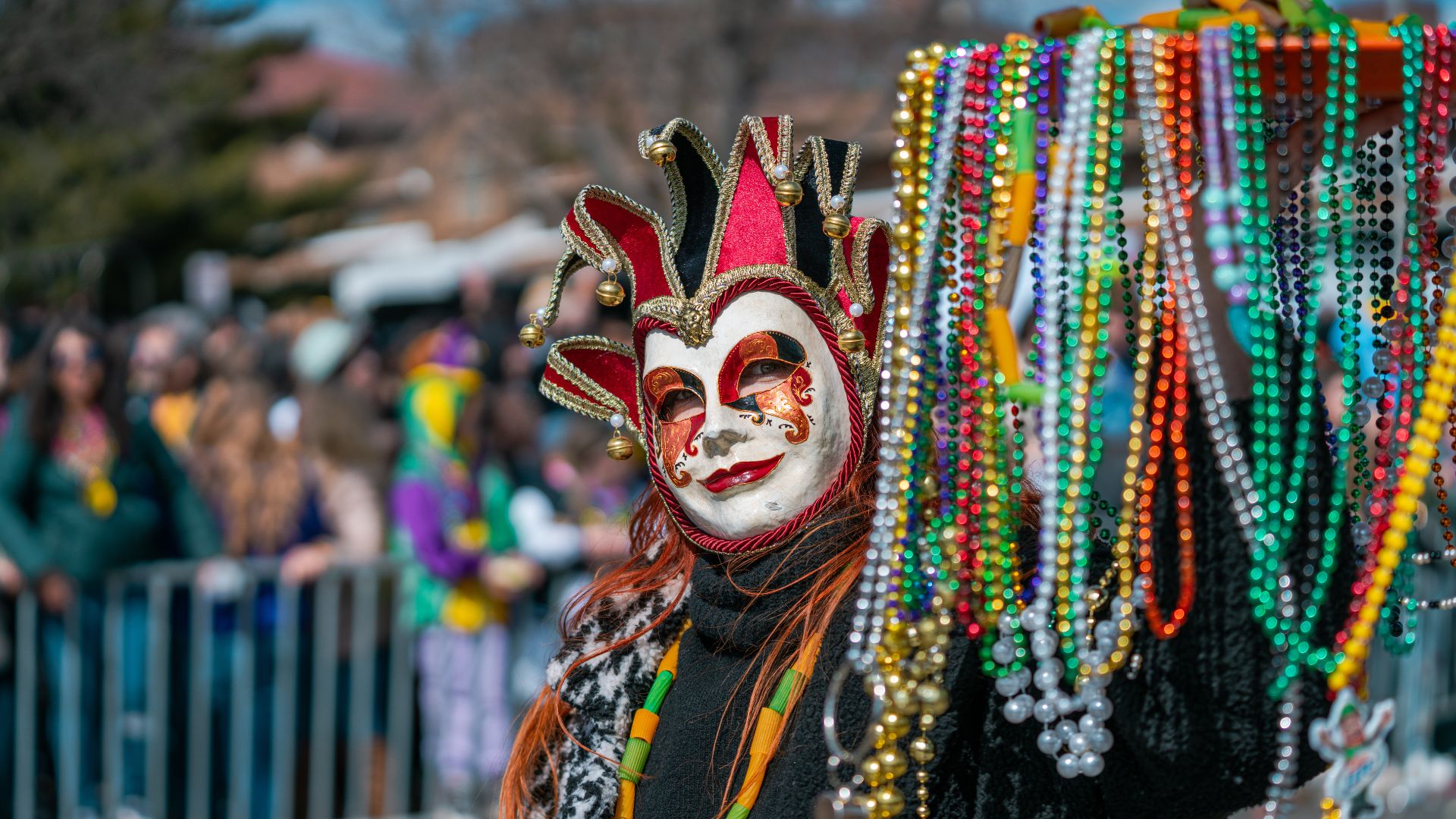 A paradegoer in a mask throws out beads during Mardi Gras in St Louis.