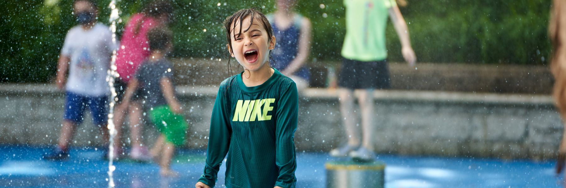 A kid plays in the water features of the children's garden at the Missouri Botanical Garden.