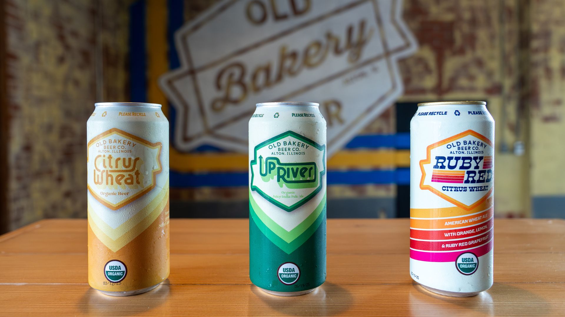 Three cans from Old Bakery Beer Co, including the citrus wheat, up river and ruby red, line a table at the Alton, Illinois, brewery.