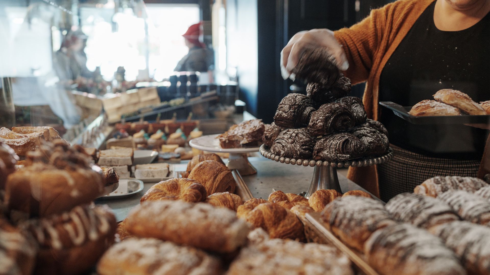 Someone refills the pastry case at La Pâtisserie Chouquette.