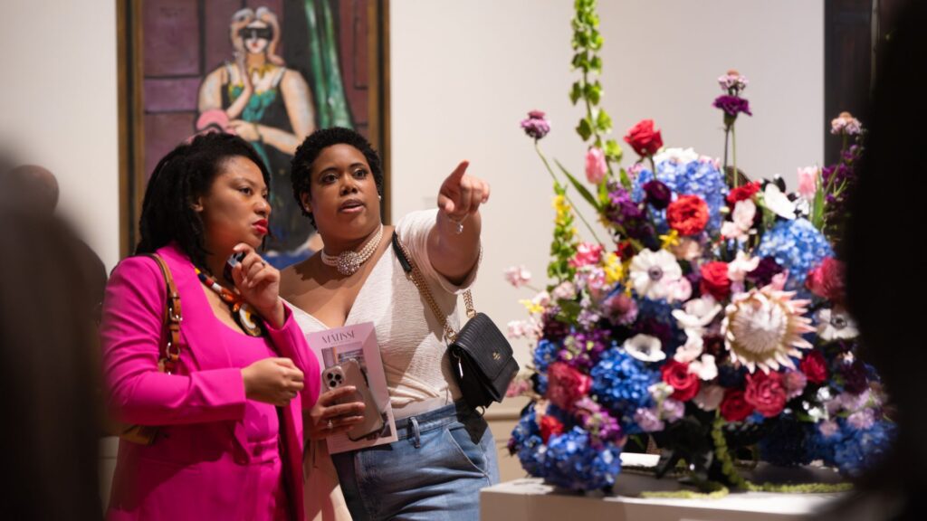Two women admire a bouquet of flowers at Art in Bloom at the Saint Louis Art Museum.