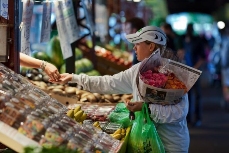 A woman buys fresh flowers at Soulard Farmers Market.