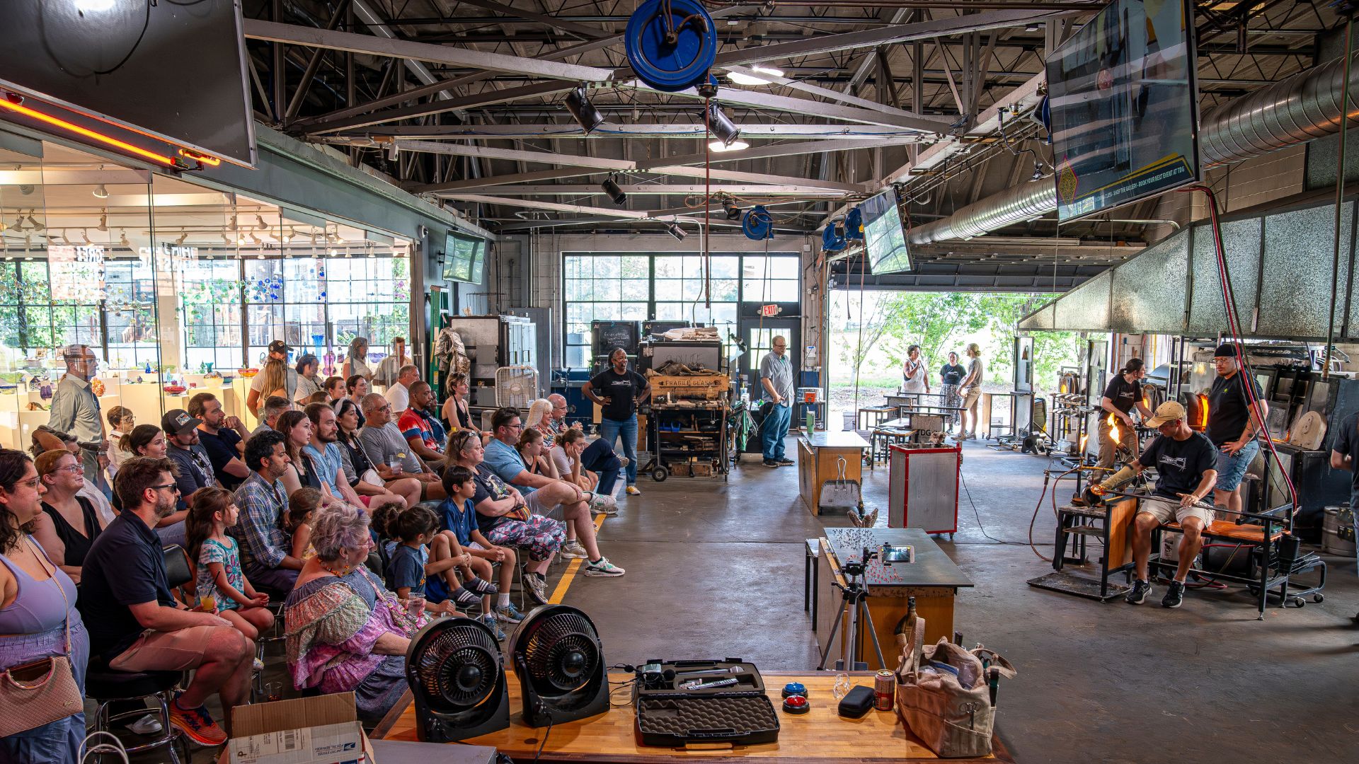 A crowd watches a glassblowing demonstration at Third Degree Glass Factory.