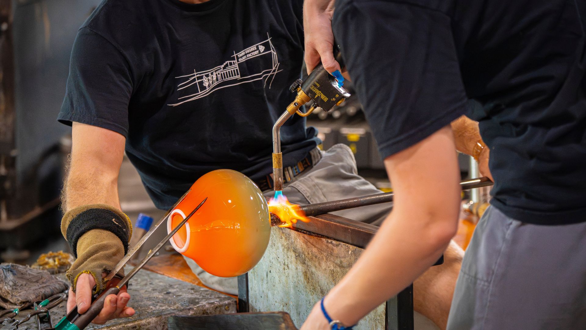 A team blows glass art at Third Degree Glass Factory, a unique St Louis event venue.