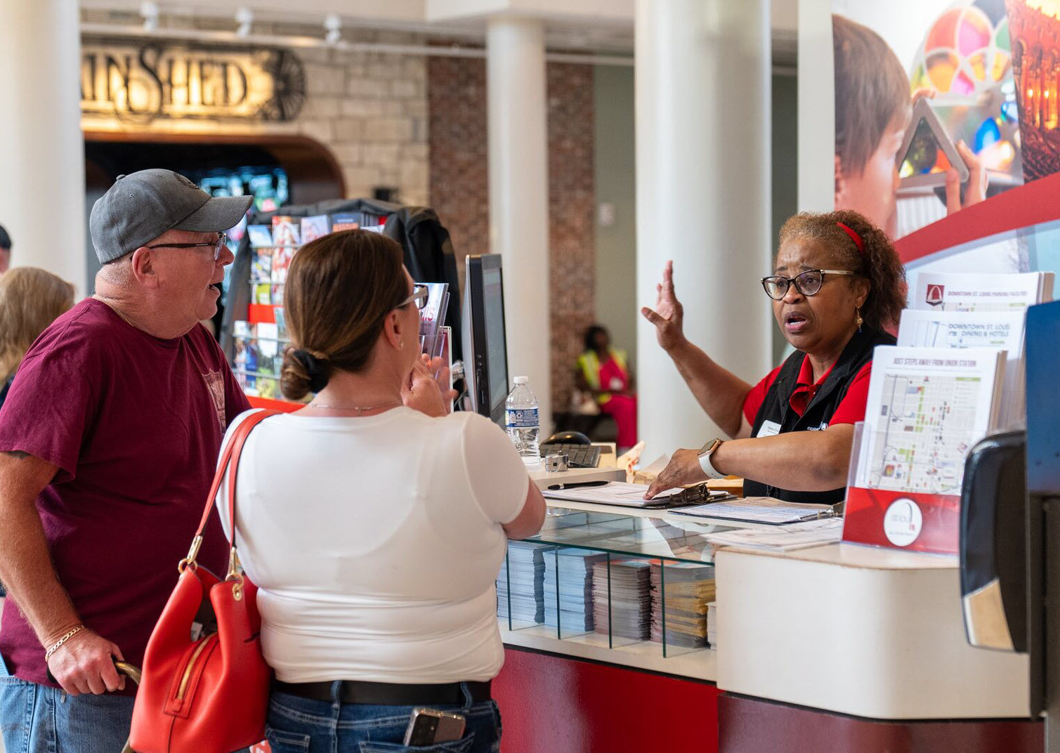 A volunteer helps visitors at the Explore St. Louis visitor center at St. Louis Union Station.
