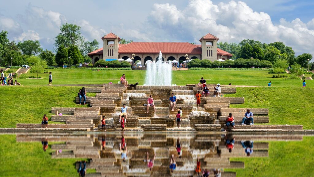 People gather on the fountain in front of the World's Fair Pavilion in Forest Park.